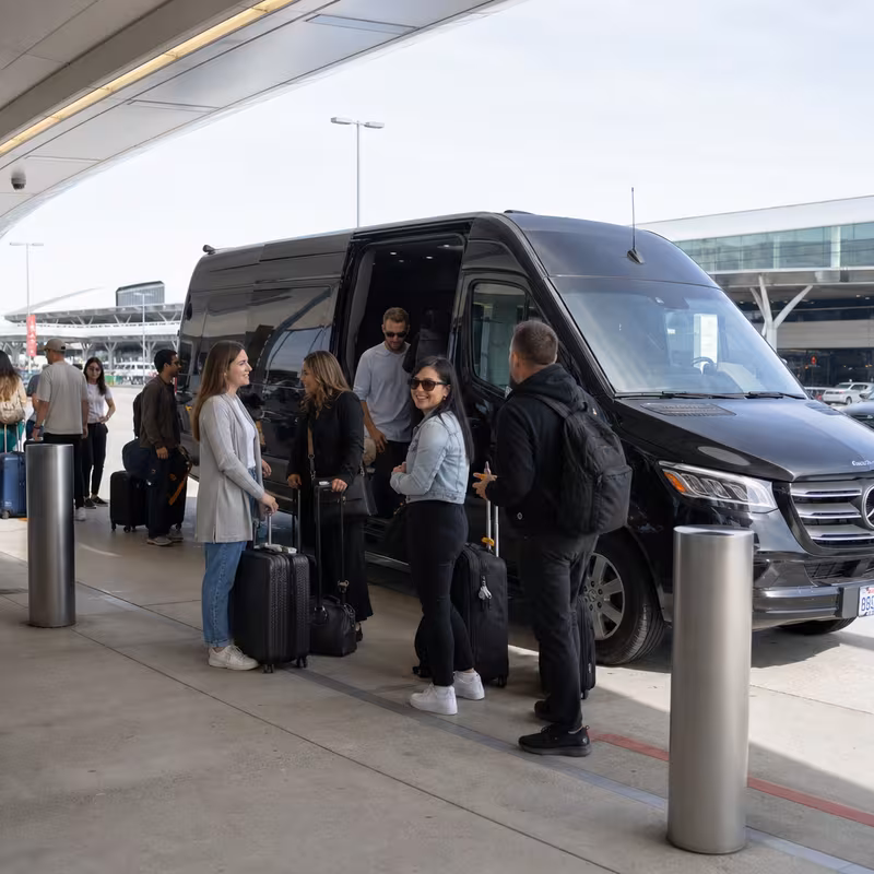 Group boarding a white charter bus for Airport Transportation transportation in Los Angeles