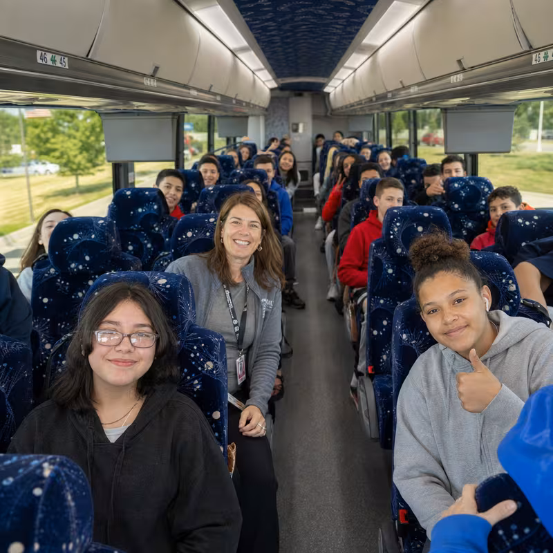 Group boarding a white charter bus for School Transportation transportation in Los Angeles